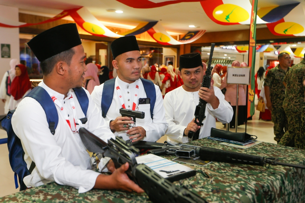 Perwakilan parti bergambar dengan senjata api di gerai Simpanan Tentera Darat Malaysia (Askar Wataniah) di WTC Kuala Lumpur 15 Januari 2026. — Gambar oleh Raymond Manuel
