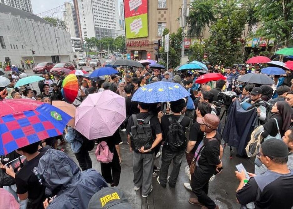 Hujan melembapkan permulaan perhimpunan ‘Tangkap Azam Baki’ di Sogo, tetapi bunga api mengejut menyebabkan kekecohan seketika (VIDEO)